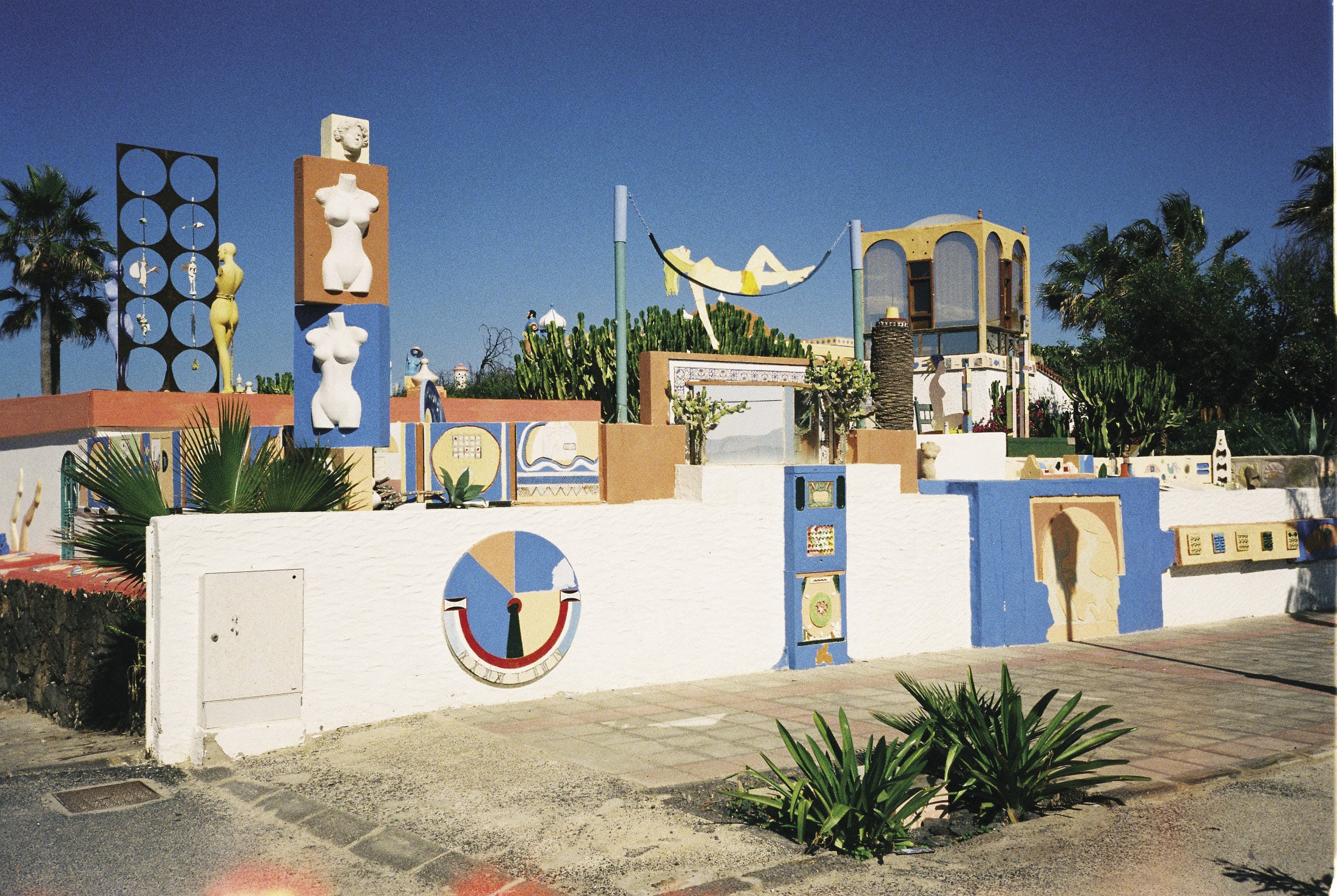 Photograph of house of Town Artist, Fuerteventura, Canary Islands, taken by the author as a reference image during the search for Social Realism, November 2012. The sculptures, reliefs and plantlife—in combination with the footpath, electrical utilities box and idiosyncratic architectural structures—illustrated in this image should be considered under the rubric of Social Realism’s inverted counterpart, Seaside Vernacular.