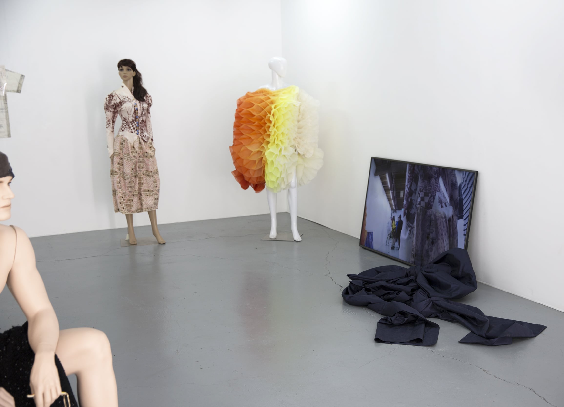 Image 02: Installation view, Gallery 1 L-R: Women’s History Museum, Orange peel fugitive purple optical dress, 2018, screen printed bodice, C. 1860 quilting print skirt, and Czech deco buttons; Zhuxuan He, Untitled, 2016, Hand-dyed silk organza; Megan Hanson, ‘…it loves
without condition or discrimination, but only once the material labour of its construction has been dismissed.’, 2018, performance video. Image: Rafaela Pandolfini.