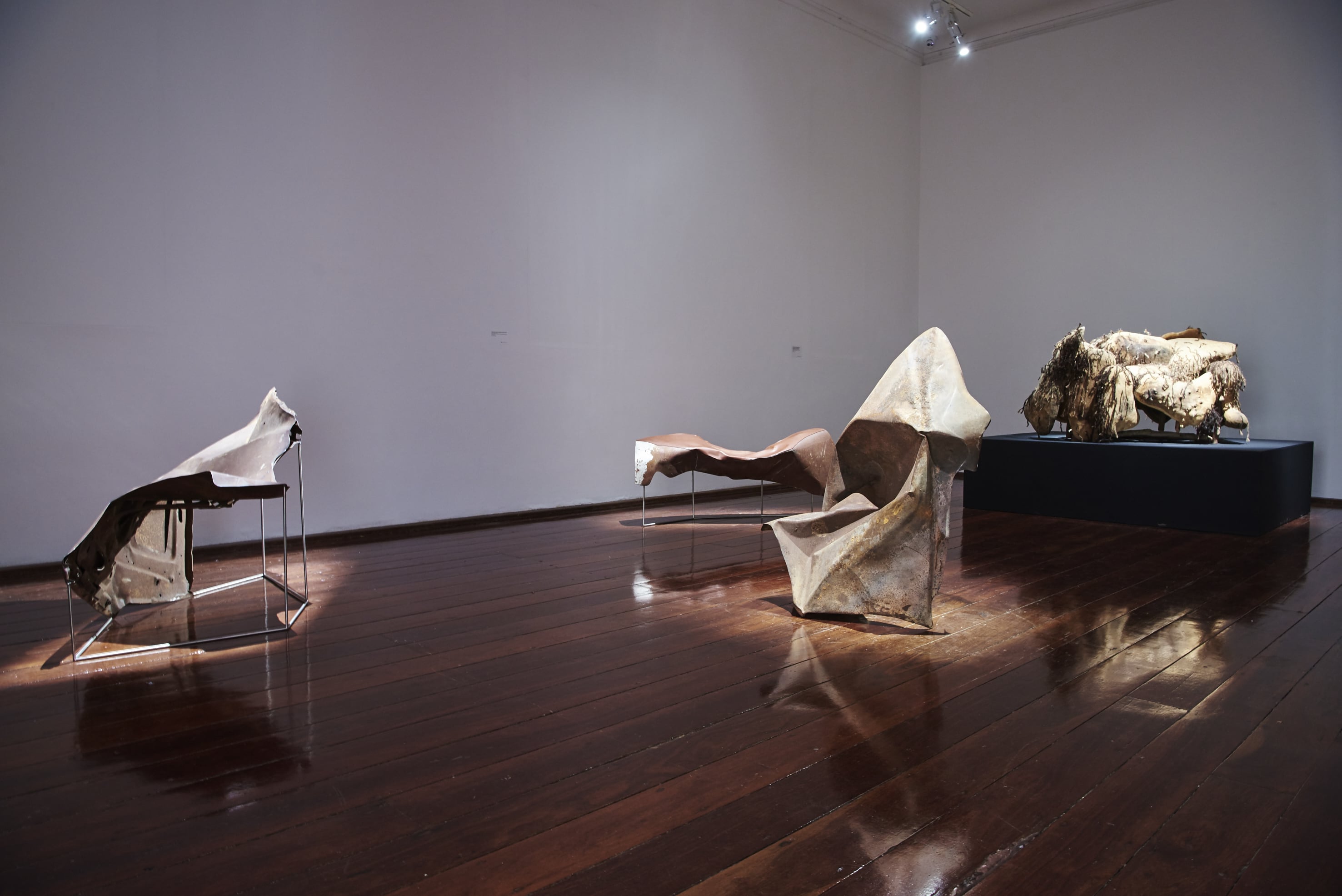 Image 03: Images from left: Trent Jansen, Johnny Nargoodah and Duane Shaw, *Collision Armchair* 2017, found car bonnet and stainless steel, 100 x 120 x 120cm. Trent Jansen, Johnny Nargoodah and Duane Shaw, *Collision Bench, 2017* found car bonnet, stainless steel and New Zealand cow leather. 55 x 120 x 60cm. Trent Jansen, Johnny Nargoodah and Duane Shaw, *Collision Vessel* 2017, found car bonnet, 60 x 130 x 60cm. Elsie Dickens, Trent Jansen, Yangkarni Penny K-Lyons, Myarn Lawford, Rita Minga, Eva Nargoodah, Illium Nargoodah, Johnny Nargoodah, Duane Shaw and Gene Tighe, *Jangarra Armchair* 2017, Jartalu wood, gum branches, human hair and fasteners. 100 x 140 x 105cm. Image courtesy of the artists. Photo: Rebecca Mansell.